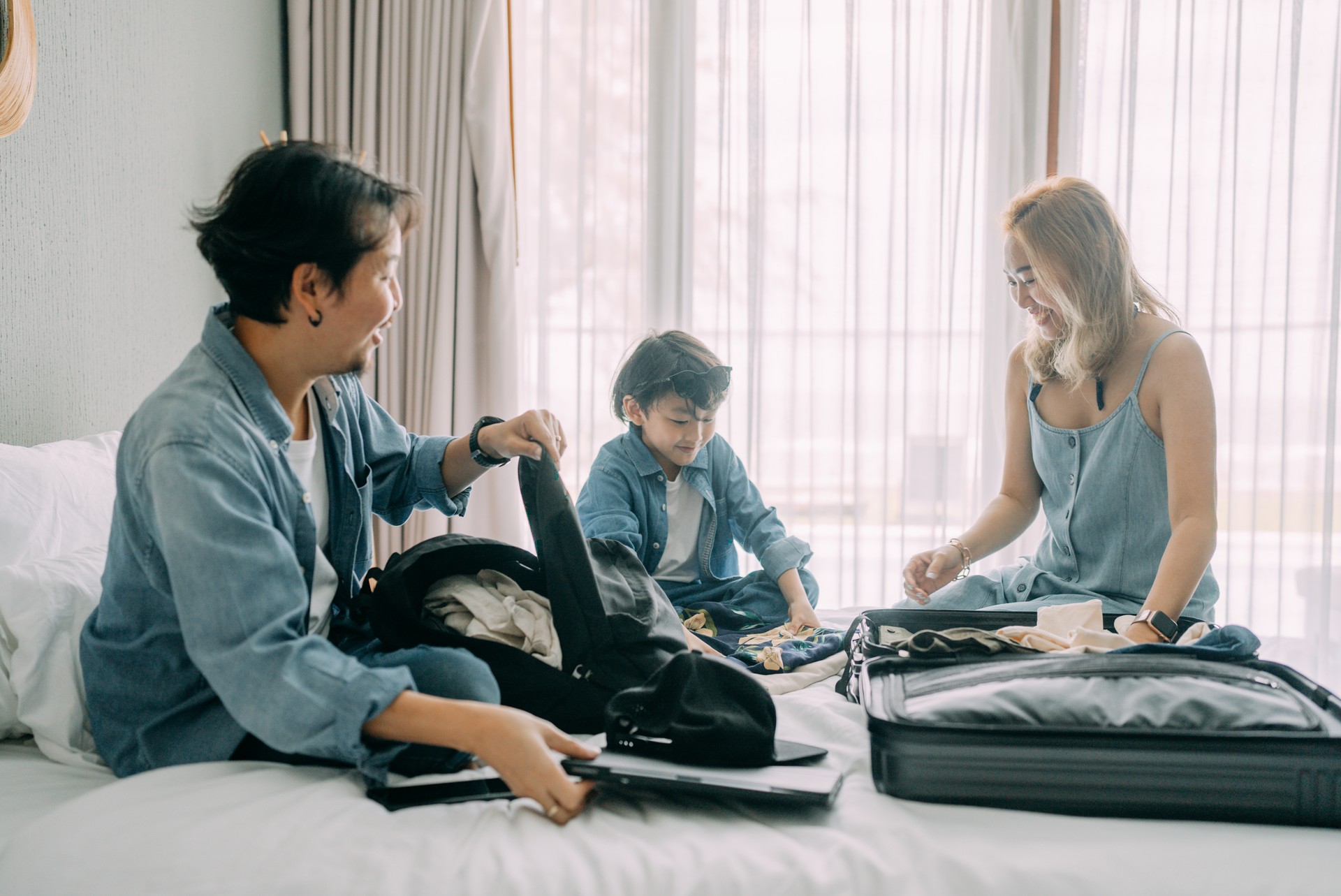 Young family traveler packing them suitcase for the next journey.